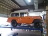 Custom built orange Jeep Wrangler on auto mechanics lift